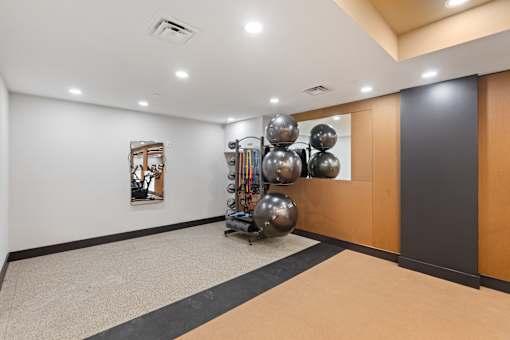 A room with a black and white striped rug and a wall with a painting and a sculpture.