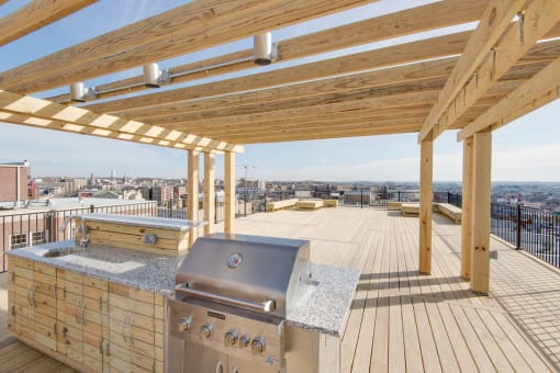 a rooftop deck with a barbecue and a view of the city at 1841 Columbia Road Apartments, Washington