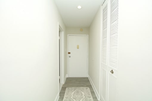 a hallway with a white door and white walls