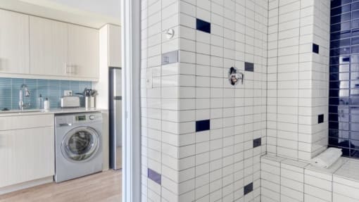 a white and blue bathroom with a washer and dryer