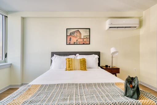 a bedroom with a bed and a painting on the wall