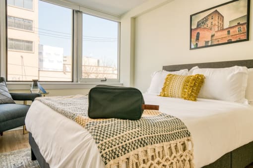 a bedroom with a large bed and three windows