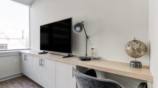 a flat screen tv sitting on top of a wooden shelf