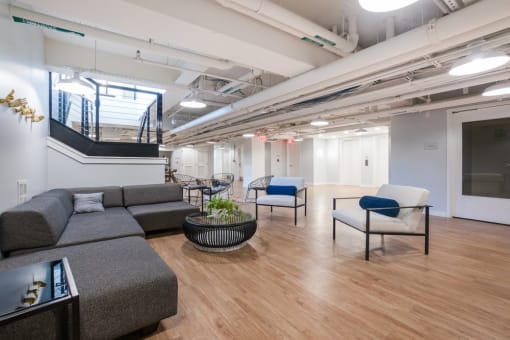 a room with couches chairs and a staircase