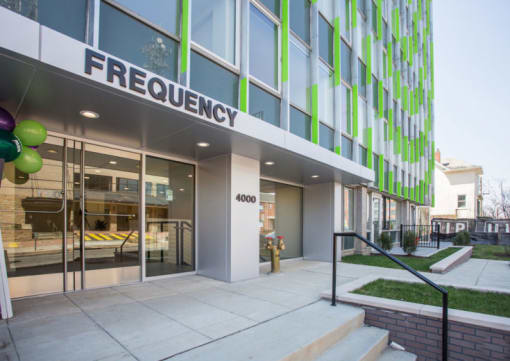 a large green and white building with a staircase in front of it