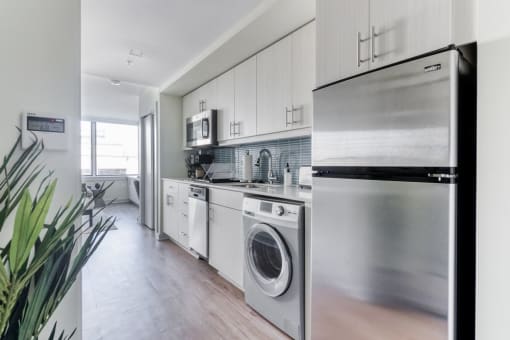 a kitchen with white cabinets and stainless steel appliances