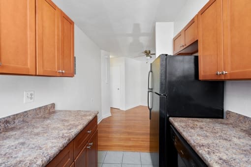 a kitchen with granite counter tops and a black refrigerator