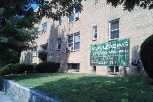 an apartment building with a sign for new leasing
