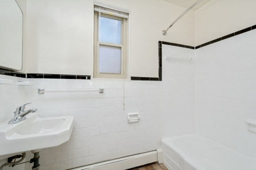 a bathroom with a sink and a tub and a window