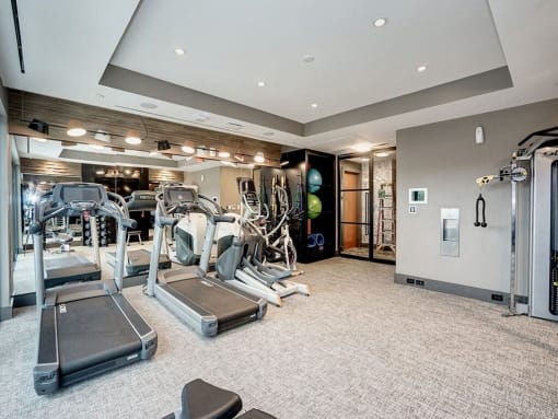 A spacious gym with treadmills, weights, and exercise equipment at Coda on H Apartments, Washington, DC