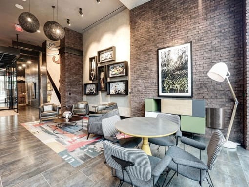 A room with a brick wall and a table with chairs at Coda on H Apartments, Washington, District of Columbia at Coda on H Apartments, Washington