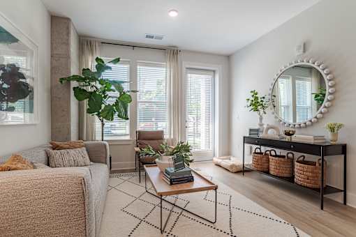 Bright living room with neutral decor and greenery at The Yancey Apartments, North Carolina