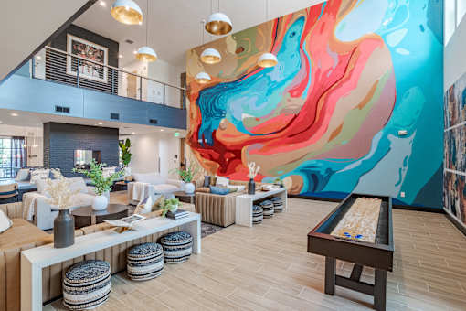 Vibrant clubhouse lounge with colorful abstract wall mural at The Yancey Apartments, North Carolina, 28217