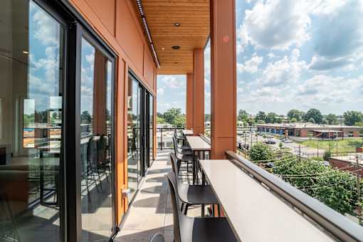 Covered balcony seating with panoramic city views at The Yancey Apartments, Charlotte, NC 28217