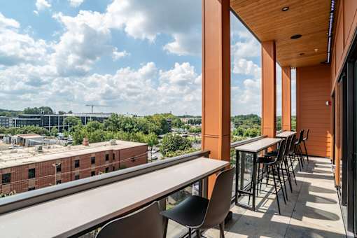 Rooftop balcony with bar height seating and skyline views at The Yancey Apartments, Charlotte, NC 28217