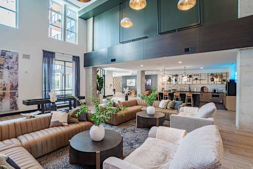 Double height clubhouse with lounge seating and kitchen at The Yancey Apartments, Charlotte, 28217