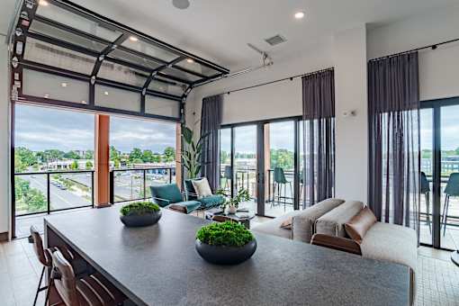 Open concept living area with garage style glass door at The Yancey Apartments, Charlotte, North Carolina