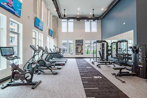 Fitness center with cardio machines and weight training area at The Yancey Apartments, North Carolina, 28217