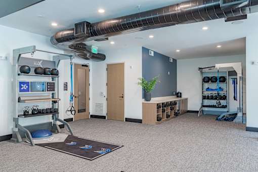 Functional training studio with equipment racks and wall storage at The Yancey Apartments, North Carolina