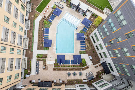 Aerial view of pool deck with lounge chairs and cabanas at The Yancey Apartments, Charlotte, NC