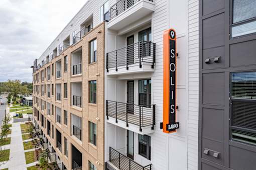 Modern apartment exterior with vertical branded signage at The Yancey Apartments, Charlotte, 28217