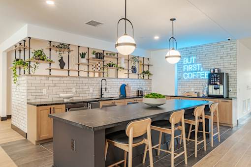 Community kitchen with island seating and coffee bar at The Yancey Apartments, Charlotte, North Carolina