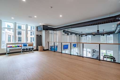 Upper level fitness area with cable railing and exposed ductwork at The Yancey Apartments, North Carolina