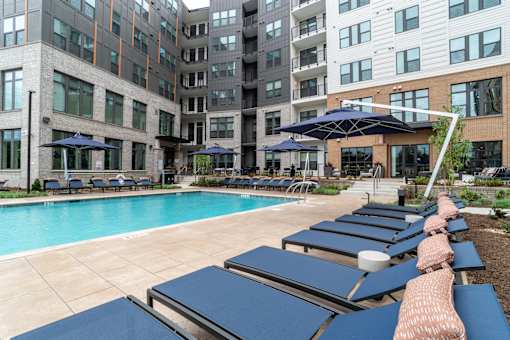 Poolside lounge area with navy blue chaise chairs at The Yancey Apartments, Charlotte, 28217