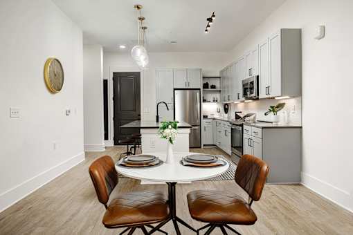 A modern kitchen with a dining table set for two at Vintage Edge Nashville Apartments, Tennessee, 37211