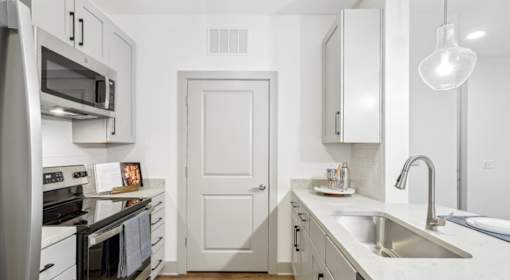 A kitchen with white cabinets and appliances at Vintage Raleigh West Apartments, North Carolina, 27607