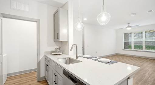 A modern kitchen with a white countertop and stainless steel appliances at Vintage Raleigh West Apartments, Raleigh, NC, 27607