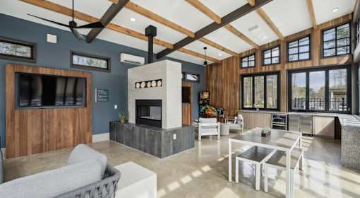 A modern living room with a fireplace and a grey sofa at Vintage Raleigh West Apartments, Raleigh, NC