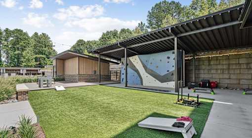 A climbing wall is in the middle of a grassy area at Vintage Raleigh West Apartments, Raleigh, North Carolina