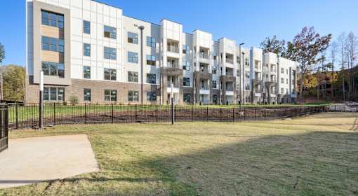 A large white building with a black fence in front of it at Vintage Raleigh West Apartments, Raleigh, North Carolina