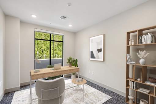 A room with a desk, chair, and a window with a view of greenery outside at Vintage Raleigh West Apartments, Raleigh, NC