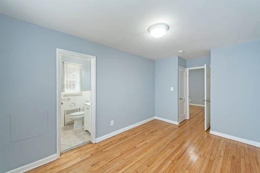 a bedroom with blue walls and a wooden floor