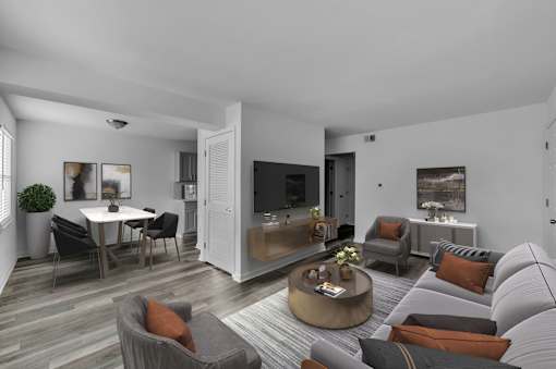 A modern living room with a grey sofa, a coffee table, and a dining table set up.