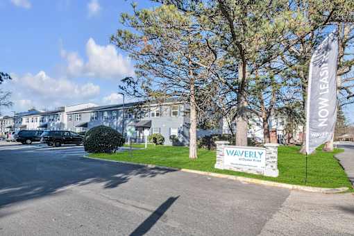 A Waverly sign is on a lawn in front of a building.