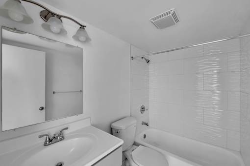 A white bathroom with a sink, toilet, and bathtub.