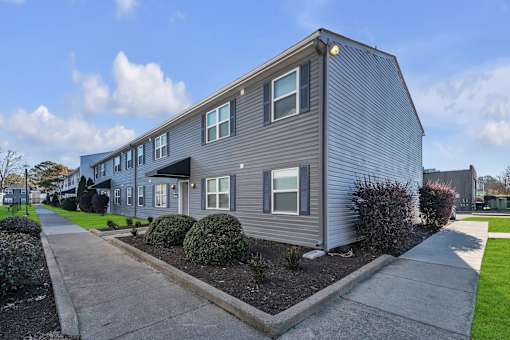 A grey house with a small front yard.