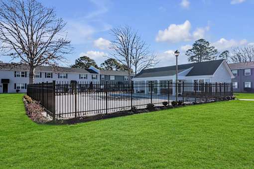 A row of houses with a black fence in front of them.