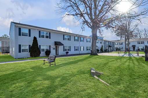 A sunny day at a grassy courtyard with apartment buildings in the background.