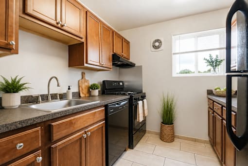 A kitchen with black appliances and wooden cabinets.