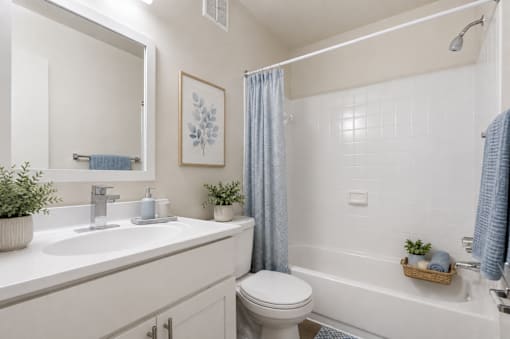 A white bathroom with a toilet, sink, and bathtub.