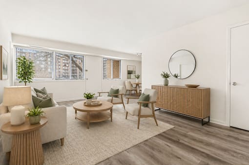 A living room with a white sofa, a wooden coffee table, and a white chair.