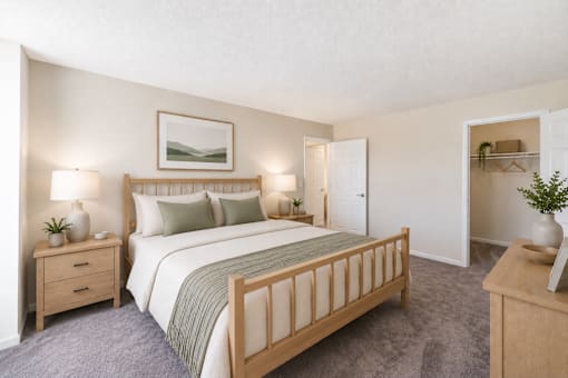 A bedroom with a large bed, two nightstands, and a dresser.