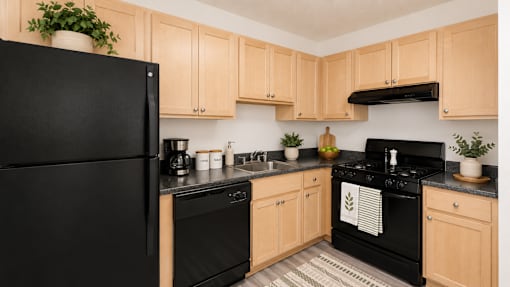 A black refrigerator is in a kitchen with wooden cabinets.