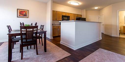 A dining room with a white island and wooden chairs at Chapel Springs Apartments, Maryland
