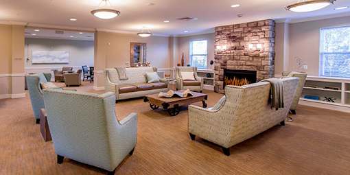 A living room with a stone fireplace and a large couch at Chapel Springs Apartments, Perry Hall, Maryland