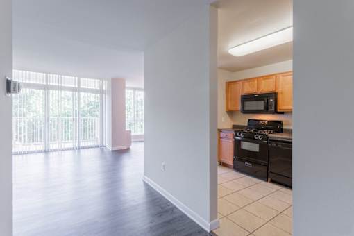A kitchen with black appliances and wooden cabinets at Charlestowne North Apartments, Greenbelt, MD
